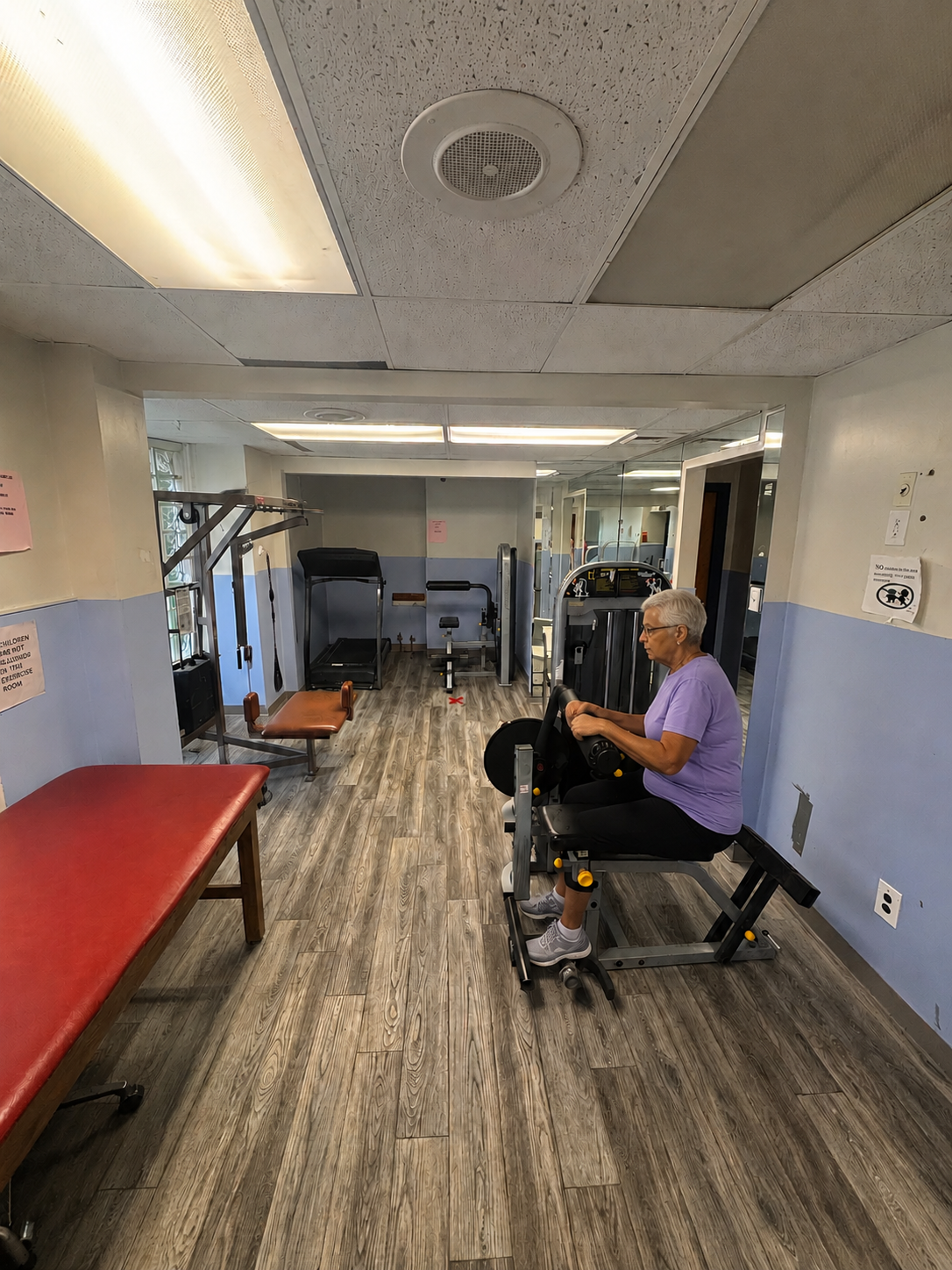 Physical therapy room with treatment tables and strength training equipment